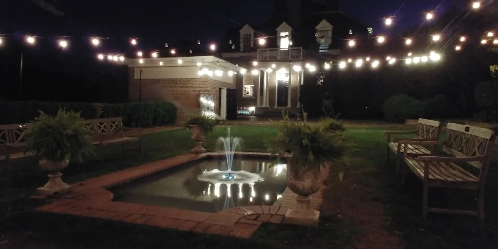 The side lawn of Woodlawn, decorated for an evening party with a smoke machine and large mirror.