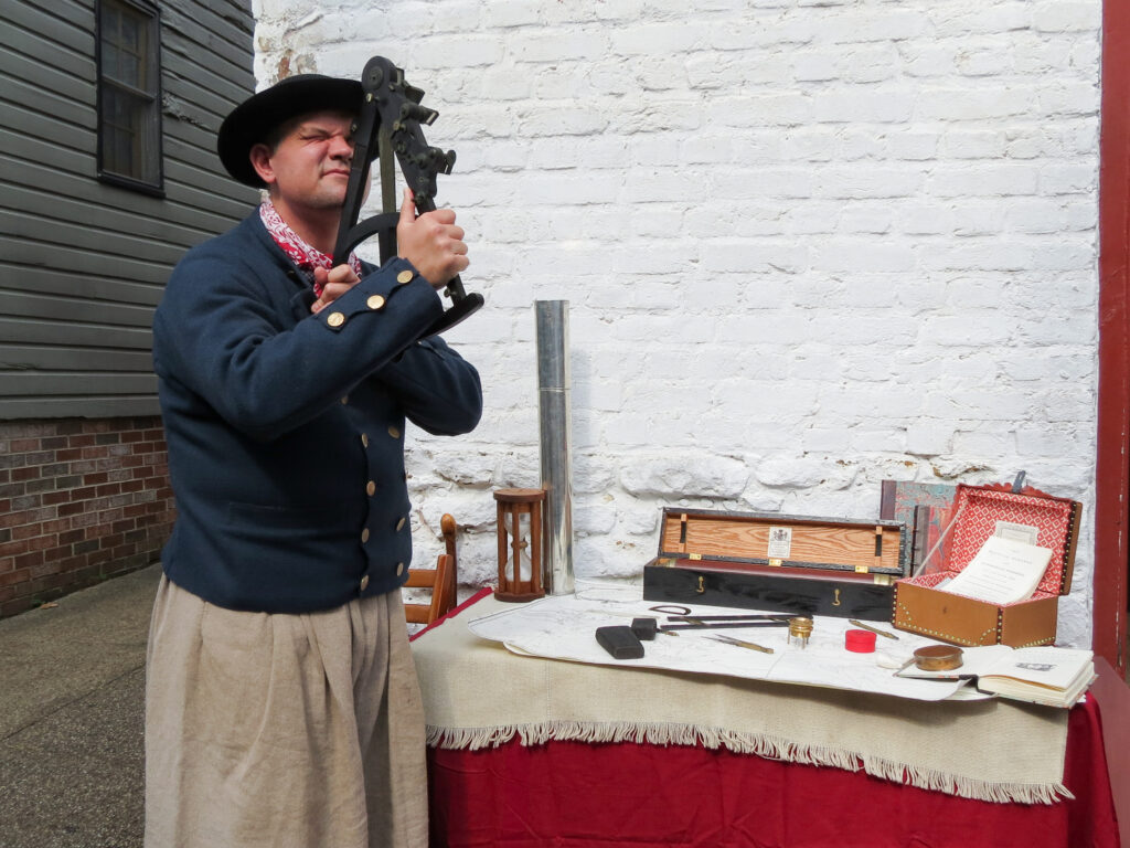 Mariner using navigation tools in Revolutionary Annapolis, 1775.