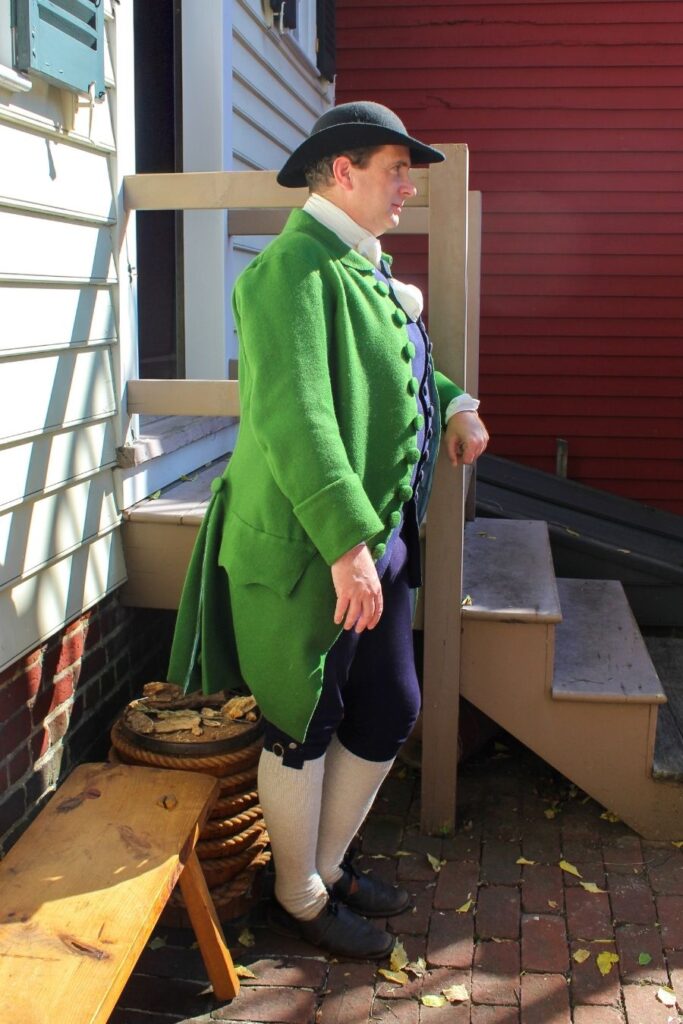 Colonial Maryland coffeehouse patron discussing revolutionary ideas.