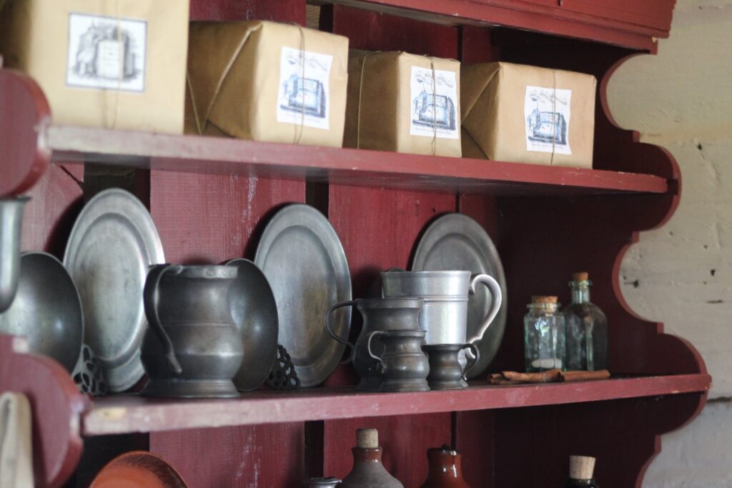 Pewter tankards and plates on a shelf behind the bar at the Sign of the Fly on the Turnip. 2021.