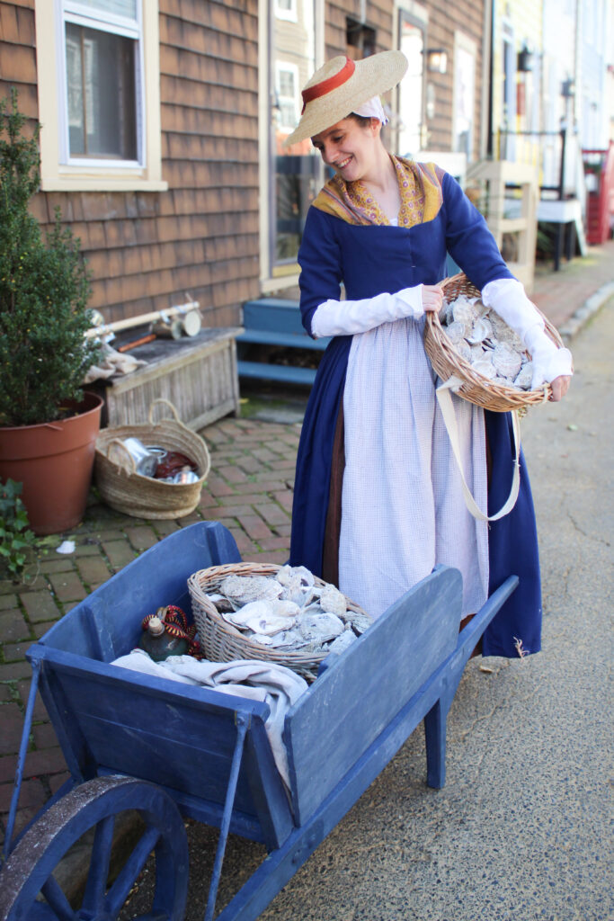 Woman interpreter with wheelbarrow of oyster shells, Annapolis living history.