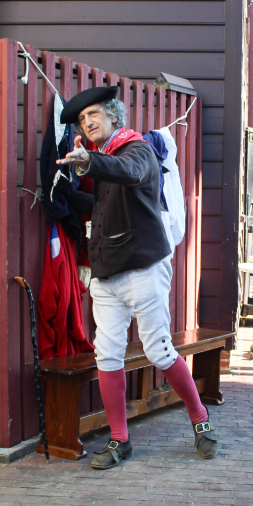 Interpreter portraying a street vendor selling second-hand clothes in 18th-century Annapolis.