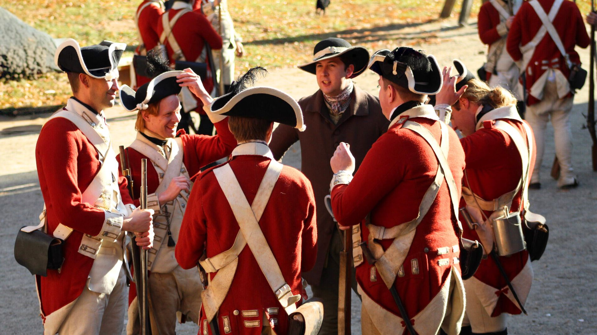 At rest and off guard, 18th-century soldiers laugh together in a candid living history photography portrait.