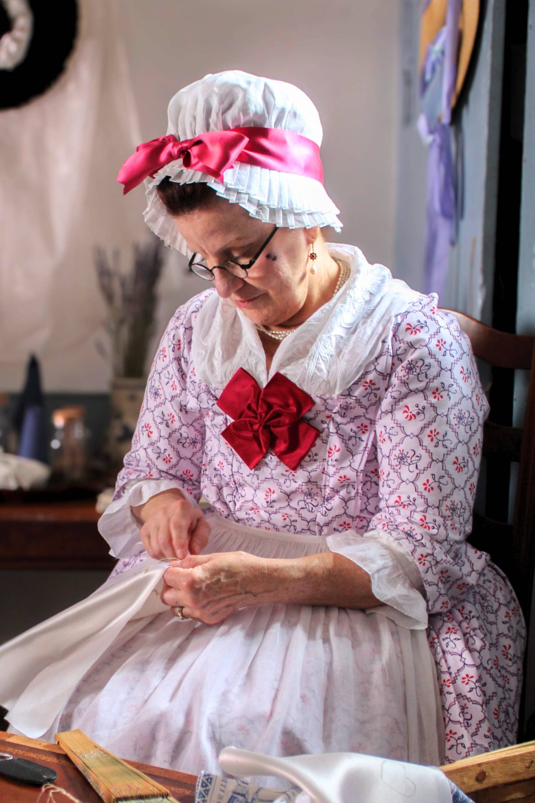 Living history photography portrait of a reenactor portraying an 18th-century milliner in a fashionable port city.