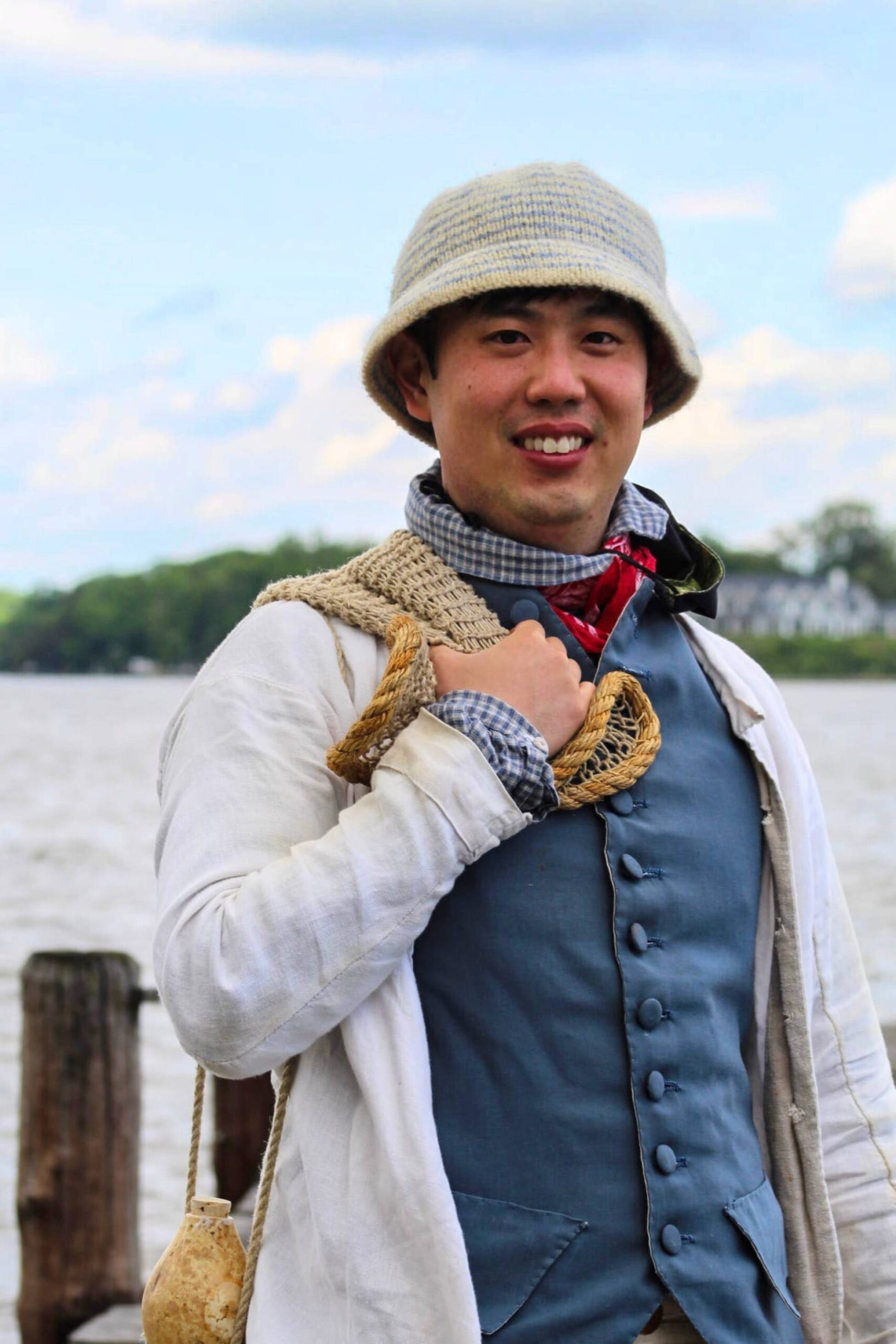 Living history photography portrait of an 18th-century fisherman reenactor before water.