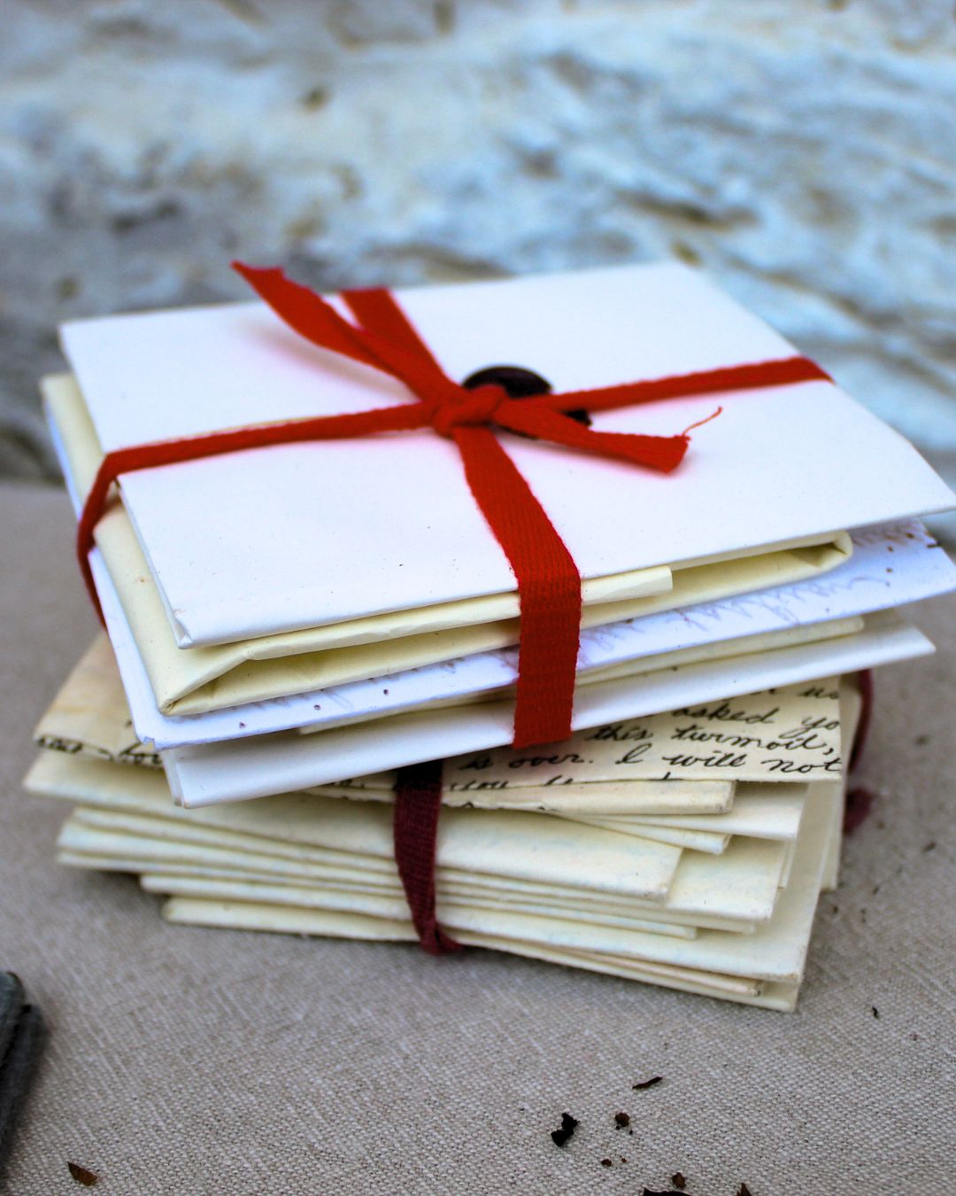 Bound letters from the 18th century, photographed in a living history photography setting highlighting historical material culture.