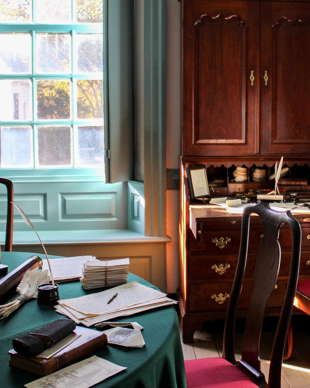 Living history photography of an 18th-century study at Colonial Williamsburg, complete with period furniture and writing materials.
