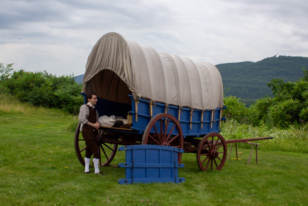 Sick soldier with Conestoga wagon at Fort Ticonderoga, Ticonderoga, NY. 2026.