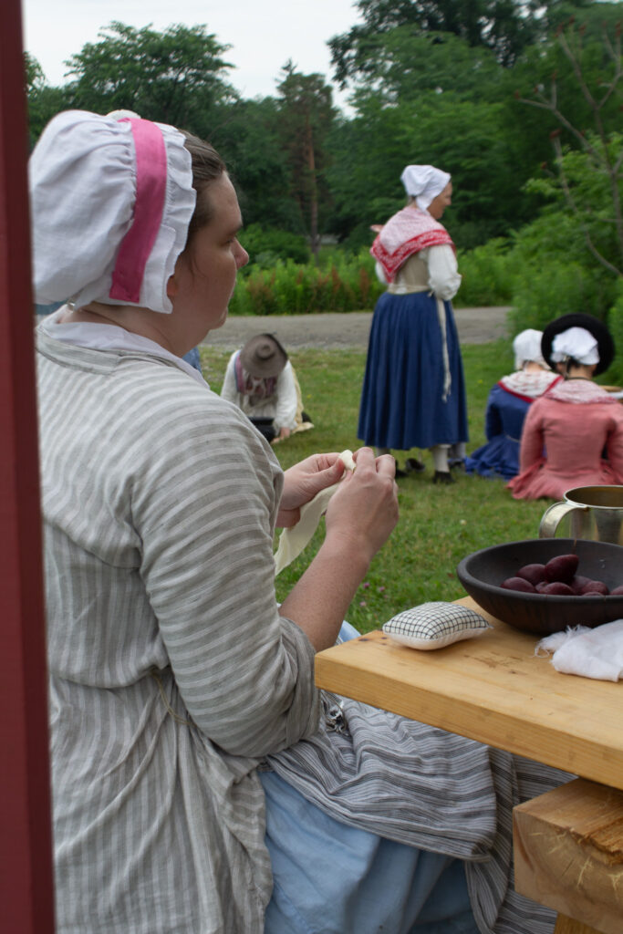 A camp follower rolls bandages at the flying hospital, Fort Ticonderoga, Ticonderoga, NY. 2026.
