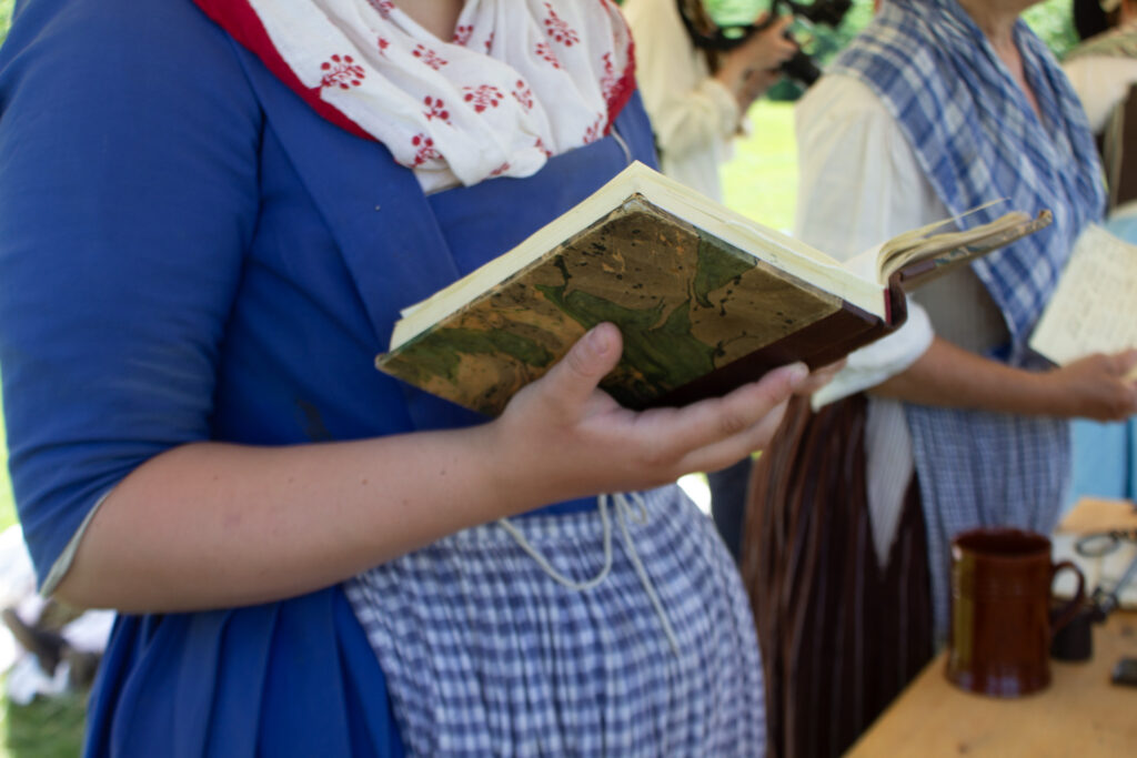Nurse consulting a medical reference at the flying hospital, Fort Ticonderoga, Ticonderoga, NY. 2026.